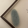 Close-up of a light blue plush faux fur hair clip with a soft lamb wool texture - Green
