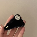 Dettaglio di un fermaglio per capelli in velluto con strass vintage e targhetta dorata - Triangolo Nero Floccaggio Strass / Nero
