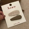 Gros plan de barrettes en tweed beige et tissu tissé vert olive sur carte d'affichage - 8# Thé au Lait Blanc Rayé Goutte