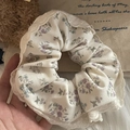 Gedetailleerde textuur van crème bloemen scrunchie met elegante witte kantrand - Paarse Bloemen Kanten Rand Stijl
