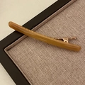 Detalle de la pinza de pelo de acetato ámbar con base de metal dorado sobre tela de yute - Caramelo