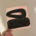 Détail de pinces à cheveux en laine noire avec fils argentés sur carte de support - Gris