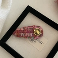 Pinza de pelo de tweed rosa con botón dorado sobre una tela de lino rústica - Pinza Triangular Púrpura Frambuesa Etiqueta Metal