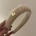 Detail of plush beige headband featuring a gold button with Believe In Yourself engraving - Milk Tea Plush