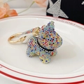 Colorful rhinestone puppy keychain with gold hardware and white woven strap accessory - Rainbow