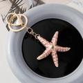 Roze emaille zeester sleutelhanger met gouden metalen afwerking en grote kreeftsluiting - Roze