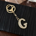 Portachiavi con lettera G dorata decorato con strass bianchi e chiusura a moschettone - Lettera G