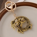 Golden dragon keychain pendant featuring sparkling brown crystals and a pearl accent - Antique Gold