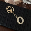 Golden keychain with lobster clasp featuring a capital letter O encrusted with rhinestones - Letter O
