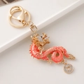 Exquisite golden dragon keychain with orange pink enamel and white rhinestones - Pink