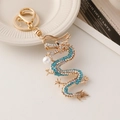Golden dragon keychain with blue crystals and white pearl pendant on s-shaped body - Blue