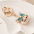 Portachiavi a coniglio dorato con fiocco di strass blu e perle bianche su vassoio - Blu