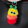 Colorful plush caterpillar keychain with sunglasses attached to a black leather bag - Yellow Head Red Tail