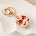 Simpatico portachiavi Topolino dorato con perle bianche e un fiocco di strass rossi - Rosso