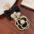 Elegant black fabric camellia flower keychain with white pearls and a bow pendant - Black