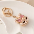 Portachiavi con coniglio di perle, fiocco di strass rosa e moschettone dorato - Rosa
