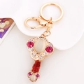 Goldener Ruyi Schlüsselanhänger mit Opal und rosa Kristallen auf weißem Hintergrund - Kurz Ruyi Rot