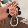 Rosa Kamelie Schlüsselanhänger mit Perlenband, schwarzer Schleife und Metallanhänger - Rosa