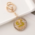Chinese dragon keychain with golden plating and yellow rhinestones on a round charm - Yellow