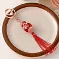 Roségouden kalebas sleutelhanger met rood emaille, 福 gravure en lange rode kwastjes - Gouden ovale gelukszegening tag