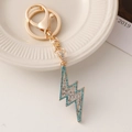 Gouden bliksemschicht sleutelhanger met blauwe en witte strass steentjes - Blauw