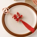 Red enamel dragon keychain with rose gold finish and decorative tassels and gems - Qilin (Kylin)