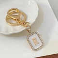 Goldener Schlüsselanhänger Buchstabe R mit Straßsteinen und weißer Emaille - Buchstabe R