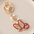 Golden butterfly keychain with red and white crystals and elegant white faux pearls - Red
