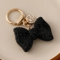 Bowknot keychain charm in black crystal inlay with golden metal spring ring and tag - Black