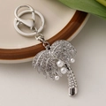 Silver palm tree keychain with sparkling rhinestones and pearls on a ceramic plate - Silver