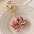 Portachiavi a forma di elefante con strass rosa e finitura dorata su vassoio bianco - Rosso
