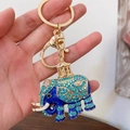 Portachiavi con elefante blu con strass e placcatura in oro mostrato in mano - Blu