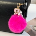 Portachiavi con pompon rosa, orsetto cuore e catena di perle su una borsa nera - Rosa Rossa