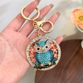 Golden owl keychain with sparkling blue crystals and pink flowers for handbag decor - Blue