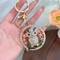 Golden owl keychain with colorful crystals and orange enamel flower detail for bags - White