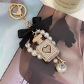 Luxury keychain with black bow, pearl chain, and diamond perfume bottle pendant - Colorful
