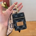 Mini borsa a secchiello nera con nastro e portachiavi dorato tenuta in mano - Nero