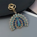 Pfau Schlüsselanhänger mit blauen Strasssteinen als eleganter Taschenanhänger in Goldoptik - Blau