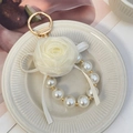 Elegante portachiavi a rosa in tessuto bianco panna con catena di perle e gancio dorato - Bianco