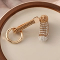 Golden sparkling rhinestone sneakers keychain with elegant champagne crystals on a dish - Champagne