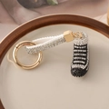 Portachiavi sneaker con strass bianchi e neri e fibbia a molla dorata lucida - Nero e Bianco