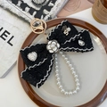 Elegante portachiavi in tweed nero con fiore di camelia e catena di perle bianche - Nero