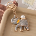 Portachiavi elefante dorato con glitter argento e perla bianca su un vassoio - Grigio