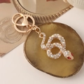Exquisite goldene Schlangenkette mit funkelnden Strasssteinen und roten Augen für Taschen - Gold