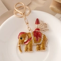 Porte-clés éléphant doré avec émail rouge et cristaux sur une assiette blanche - Doré