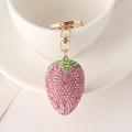 Detailaufnahme des Erdbeeren-Schlüsselanhängers mit rosa und grünen Strasssteinen an Tasse - Rosa