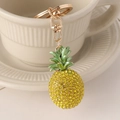 Elegante portachiavi a forma di ananas con strass e moschettone dorato su vassoio - Giallo