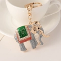 Golden elephant keychain with silver glitter and green enamel saddle details - Gray