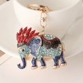 Golden elephant keychain with blue rhinestones and red feather accent for bags - Red