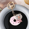 Llavero de oso dorado con dona de esmalte rosa y brillantes detalles de pedrería - Rosa